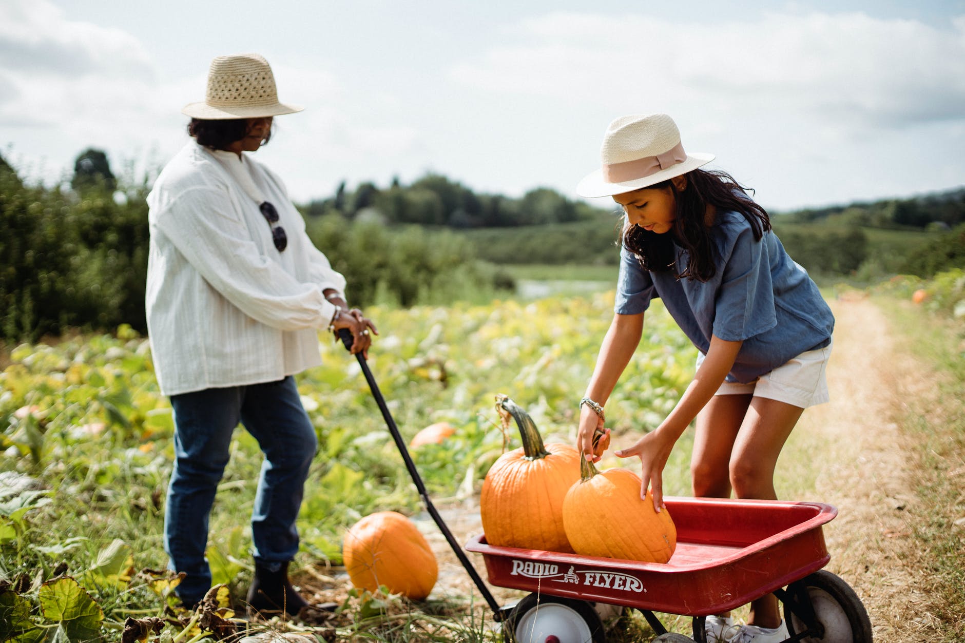 woman with daughter in field with pumpkins